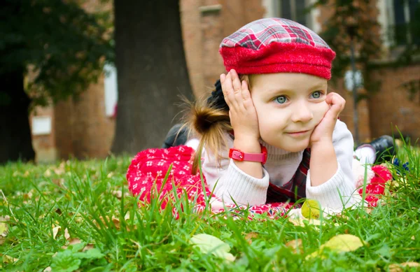 Klein meisje liggen op het gras — Stockfoto