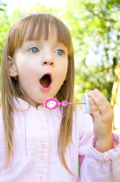 Mała dziewczynka dmuchanie bańki mydlane — Zdjęcie stockowe