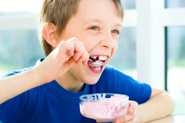 Ung pojke äta en välsmakande glass Stockfoto