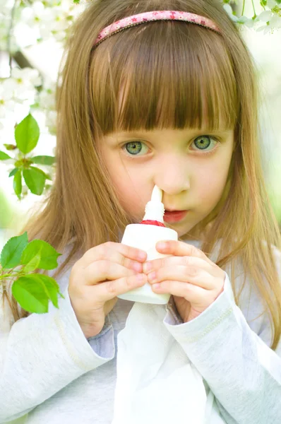 Meisje sproeien geneeskunde in de neus. — Stockfoto