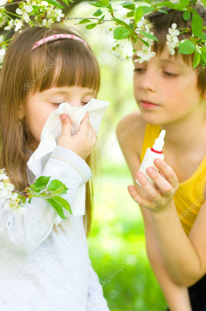 girl is blowing her nose outdoors