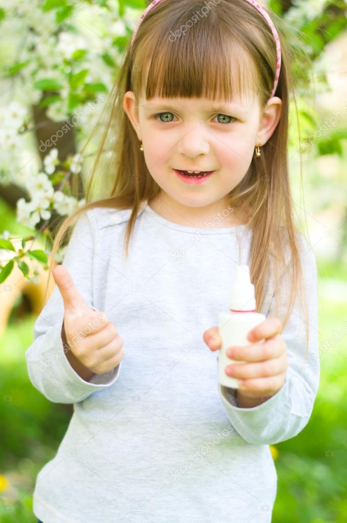 girl holding nasal spray,showing thumbs up