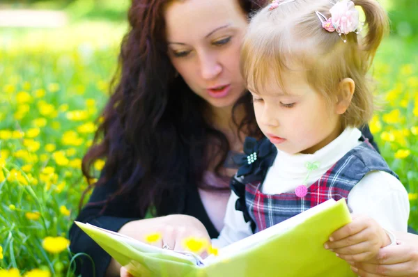 Moeder met dochter lezen een boek — Stockfoto