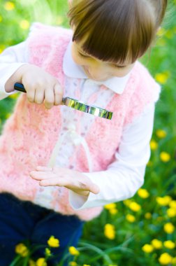 Kız el büyüteç kullanarak incelenmesi