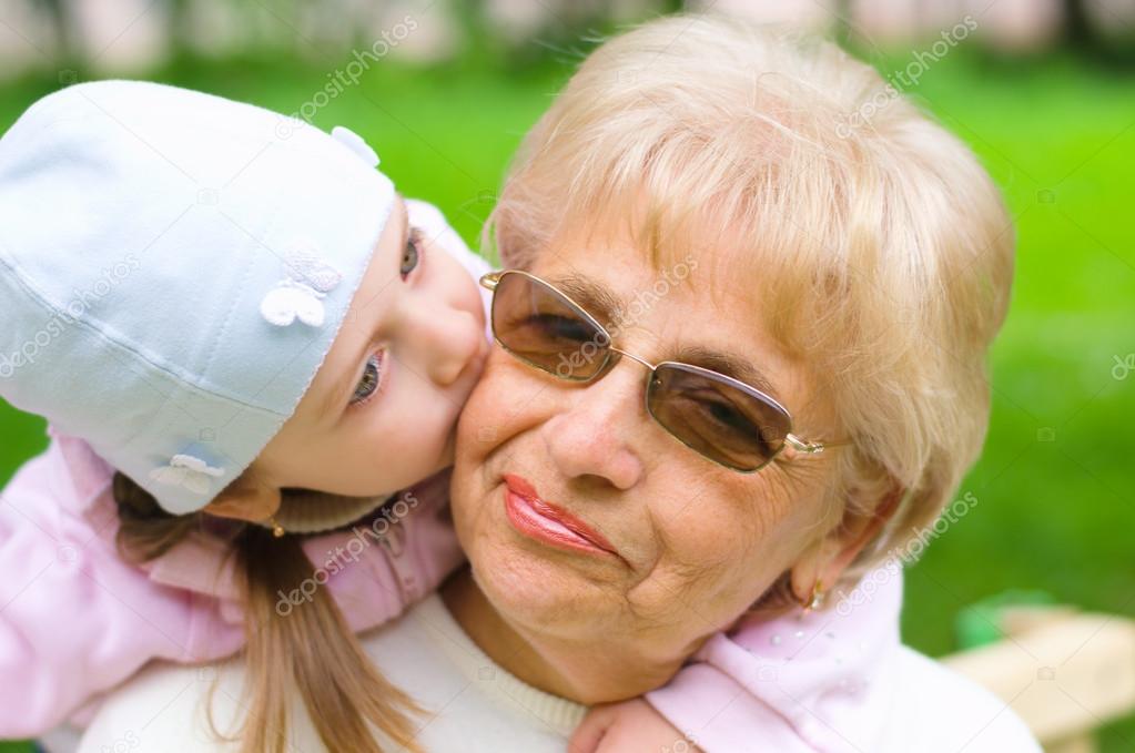Grandmother getting a kiss from granddaughter