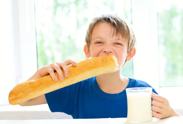 Jongen met melk en lange brood — Stockfoto