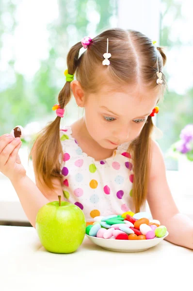 Girl with apple and sweets — Stock Photo, Image