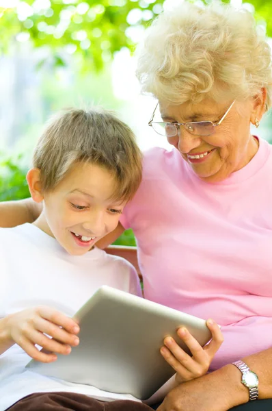 Маленький мальчик с бабушкой с помощью планшетного ПК — стоковое фото