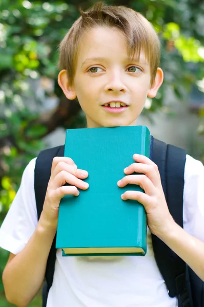 Écolier avec sac à dos et livre — Photo