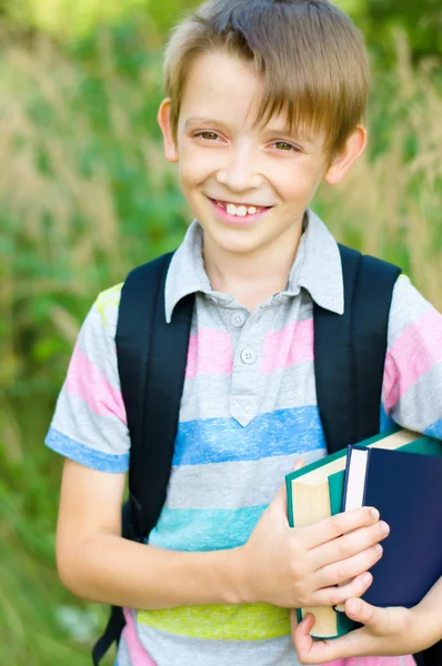 Schoolboy with backpack and books — Stock Photo, Image