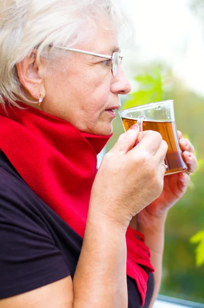 Old woman drinking tea — Stock Photo, Image