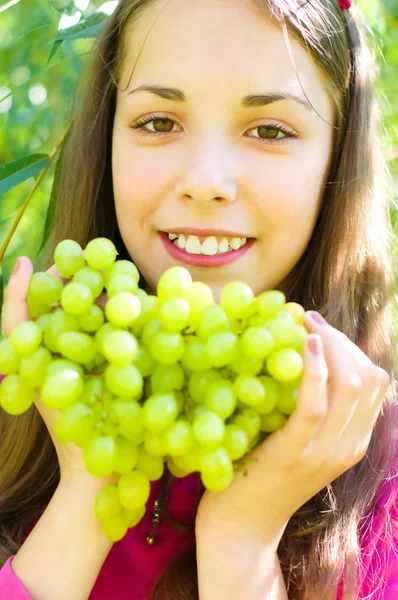 Girl is eating grapes — Stock Photo, Image