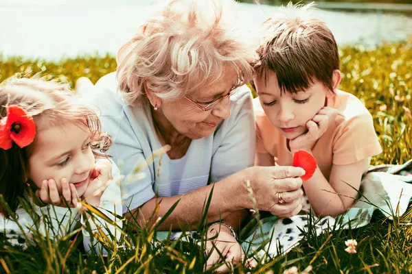 Happy grandmother with grandchildren outdoors — Stock Photo, Image