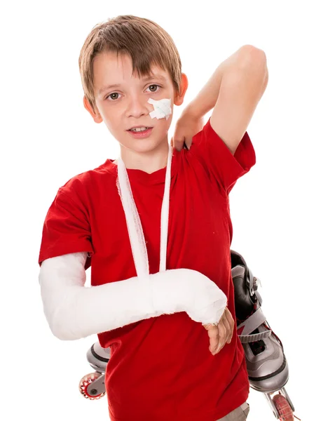 Chlapec se zlomenou rukou drží kolečkové brusle — Stock fotografie