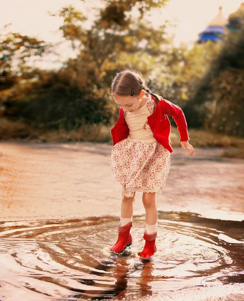 Kid springen in een plas — Stockfoto