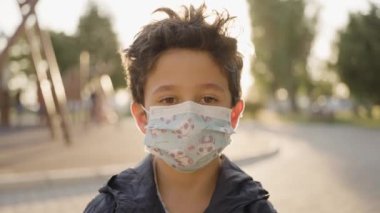 Üzgün Lillte Boy Child kameraya bakan ev yapımı bir solunum maskesi takıyor. Coronavirus koruması. 