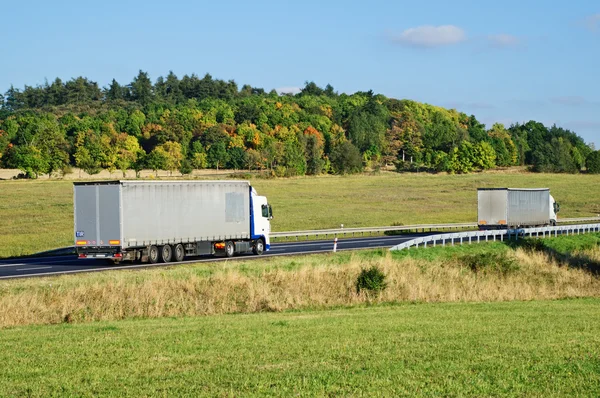 Twee vrachtwagens op de weg op het platteland — Stockfoto
