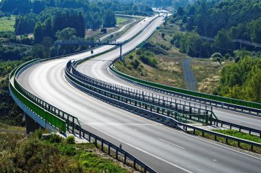 Empty highway between forests in the landscape clipart