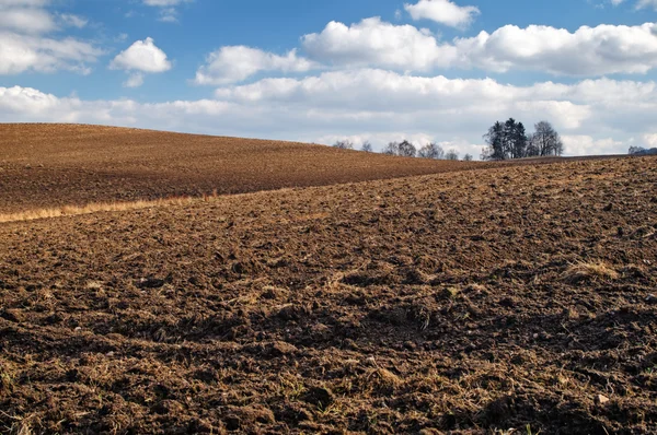 Campo arato ondulato all'inizio della primavera — Foto Stock