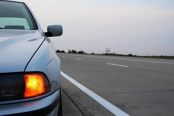 Luces de emergencia del coche en carretera fuera de la ciudad —  Fotos de Stock