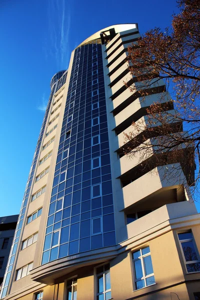 New high rise apartment building and part of bare tree — Stock Photo, Image