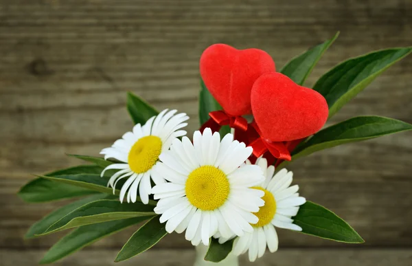 Bouquet avec marguerites et deux cœurs rouges — Photo