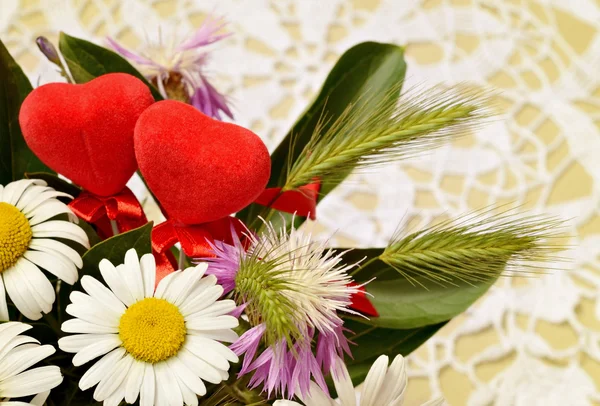 Buquê de flores wid e dois corações no fundo de crochê — Fotografia de Stock