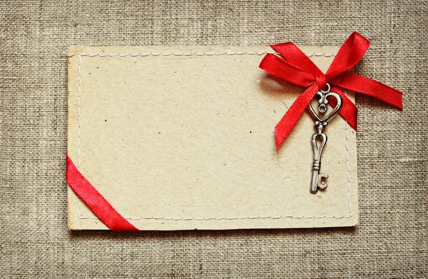 Tarjeta de felicitación con cinta roja y llave — Foto de Stock