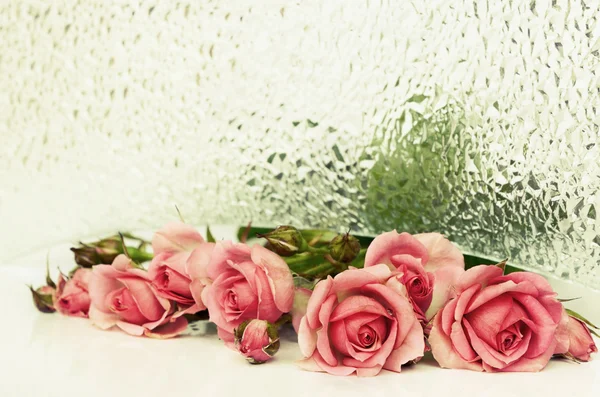 Różowe kwiaty róży i szkło teksturowane — Zdjęcie stockowe