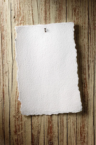 Paper sheet on aged wooden wall — Stock Photo, Image