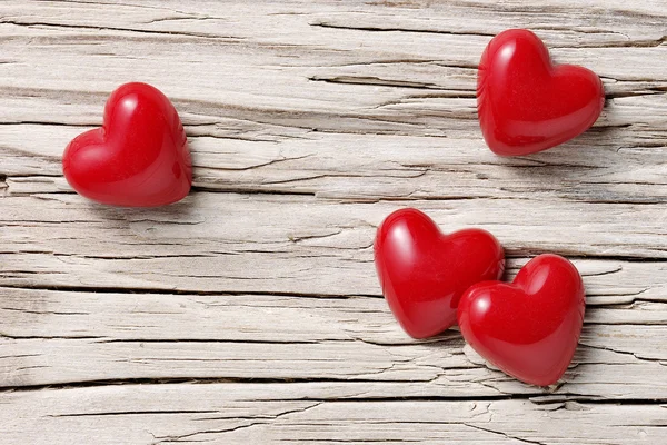 Four hearts on white wood — Stock Photo, Image