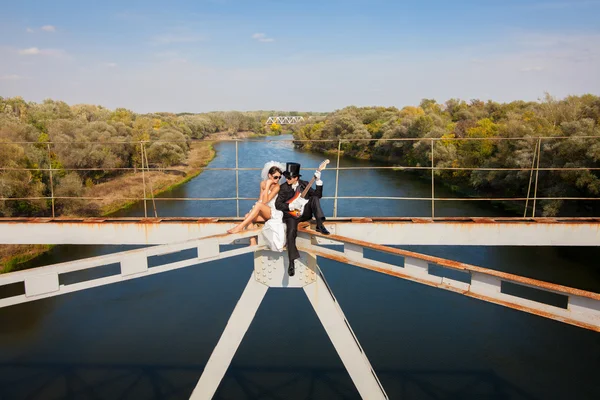 Mariée et marié sur le pont sur la rivière — Photo