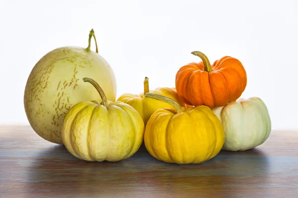 Citrouilles et cantaloup avec fond blanc sur bois vintage — Photo