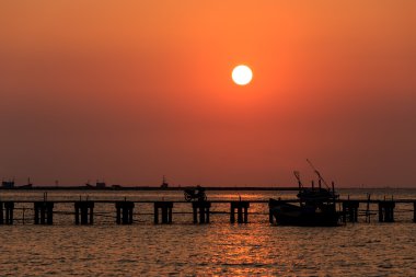 Günbatımına ahşap iskele ve gemi