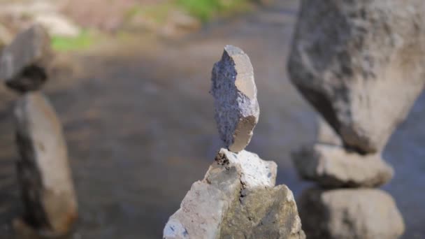 El concepto de equilibrio. Pirámide de piedras contra el fondo de un río de montaña. Armonía de la naturaleza y la meditación — Vídeo de stock