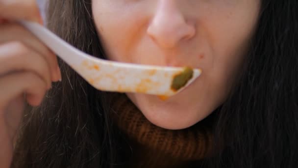 Detailní záběr mladé ženy jíst lžíci mastné kořeněné polévky z asijské kuchyně — Stock video