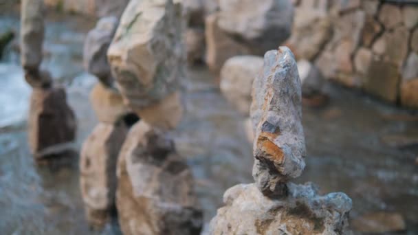 산의 강 바닥에 있는 다른 돌의 균형을 맞추는 돌의 근접 사진. 자연에서 힘의 균형이라는 개념 은. — 비디오