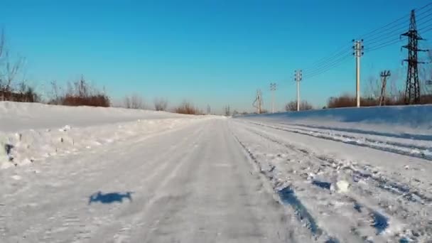 Latać latać nad zimową śnieżną drogą na wsi. Niski lot quadrocopterem nad śnieżną autostradą. — Wideo stockowe