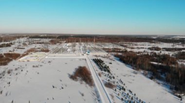 Orman arasında kış mevsiminde bir elektrik santralinin 4K hava görüntüsü. Elektrik üretimi