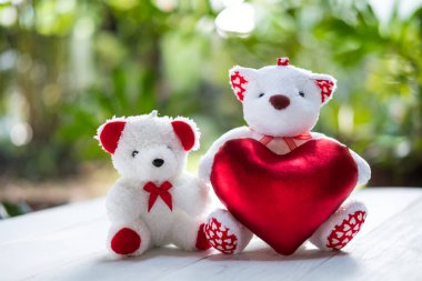 Küçük beyaz ayı sevgililer günü hediyesi olarak kırmızı kalbi tutuyor..