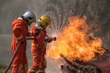 İtfaiyeci yangını söndürmek için su püskürtüyor..