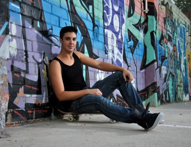 genç adam kaykayıyla poz