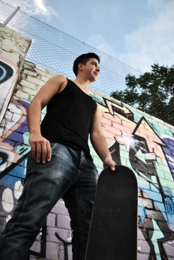 genç adam kaykayıyla poz