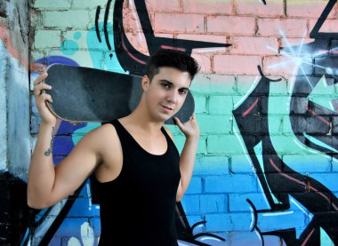 genç adam kaykayıyla poz