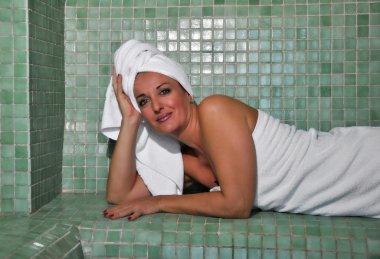 Türk hamamında oturan kadın