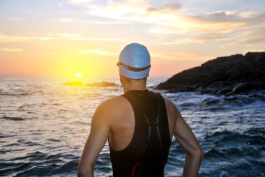 Genç sporcunun triatlon bir gündoğumu önünde