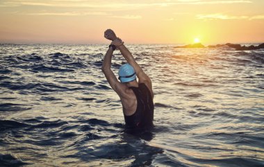 Genç sporcunun triatlon bir gündoğumu önünde