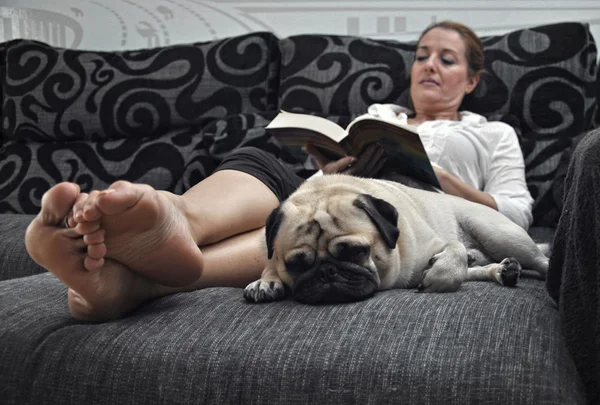Donna che legge sul divano tranquillamente io — Foto Stock