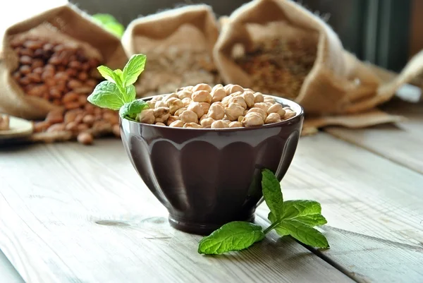 Garbanzos crudos en un tazón marrón — Foto de Stock