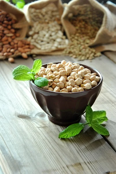 Garbanzos crudos en un tazón marrón — Foto de Stock